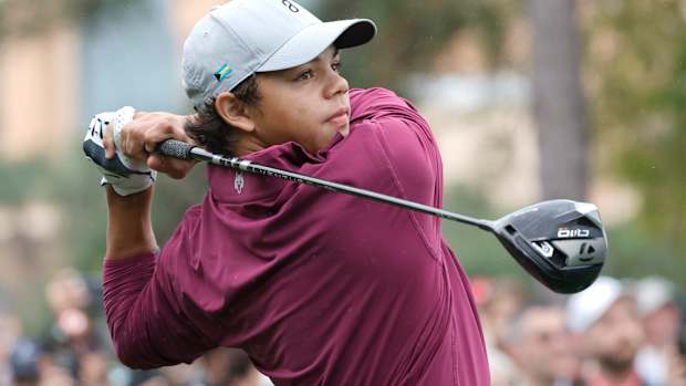 Charlie Woods plays his shot from the first tee during the PNC Championship at The Ritz-Carlton Golf Club